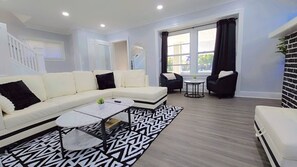 Ein modernes Wohnzimmer mit einem Ecksofa, einem Couchtisch und zwei Sesseln.