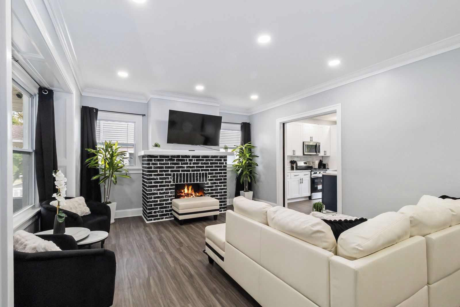 A modern living room with a fireplace, a flat-screen TV, and a sofa.