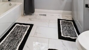 Un baño con bañera, ventana con vistas, toallero y retrete.