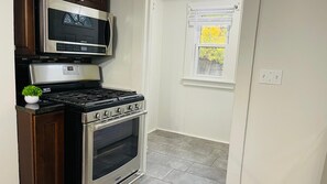 A compact kitchen with a stainless steel stove, oven, and microwave. - The West Blvd 2bedroom Central close to HWY (Cleveland)