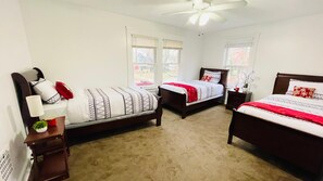 A bedroom with two single beds, a ceiling fan, and a window with blinds. - Central West Blvd 2bedroom Apartment close to HWY (Cleveland)