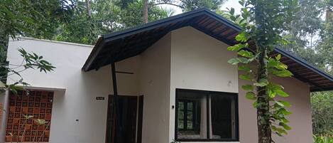A modern two-story house with a flat roof, large windows, and a small porch.