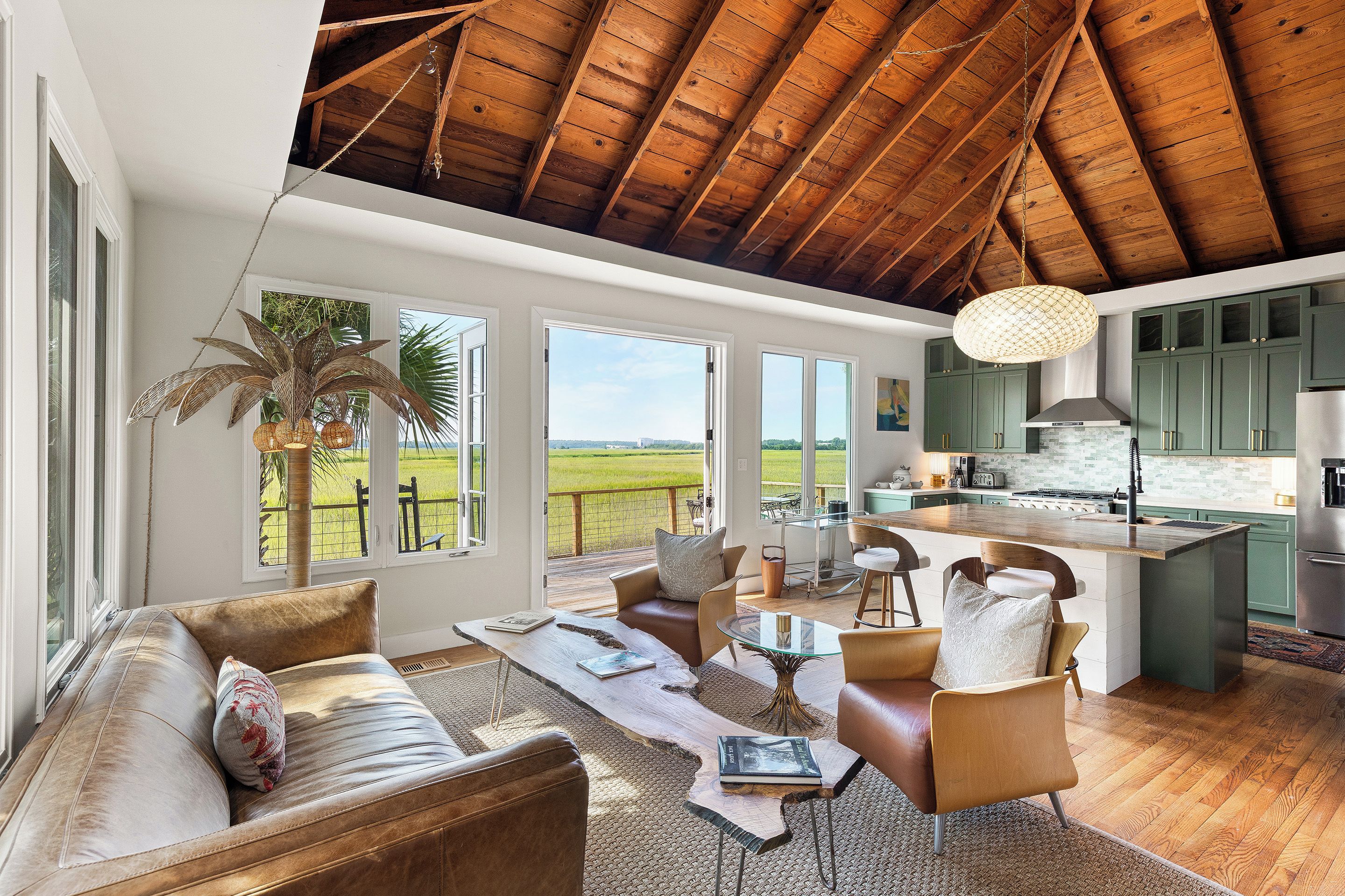 Un salón amplio con techos altos, ventanas grandes y vistas al exterior.