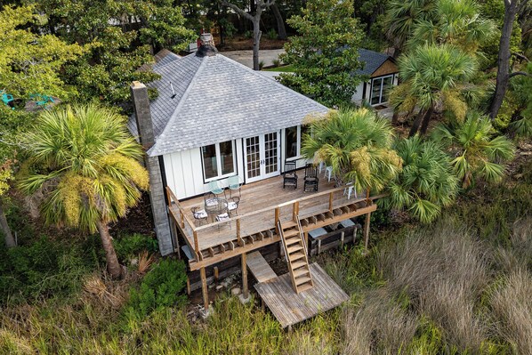 Una casa con terraza, rodeada de vegetación tropical exuberante.