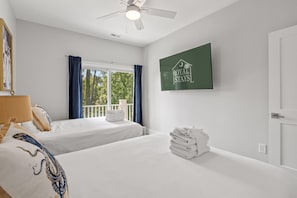 A hotel room with two beds, a ceiling fan, a window with curtains, a wall-mounted TV, and a sign that reads 'ROYAL STAYS'. - Electric Octopus-2.5 Blocks-Beach-Pets (Myrtle Beach)