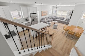 A modern kitchen with white cabinets, a stainless steel refrigerator, and a coffee maker on the counter. - Electric Octopus-2.5 Blocks-Beach-Pets (Myrtle Beach)