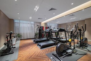 A gym with treadmills, elliptical machines, and weight equipment.