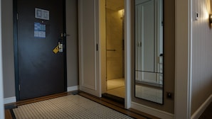 A hotel entrance with a dark door, a visible security lock, a tiled floor, and a mirror reflecting part of the room. - Paco Hotel Chimelong Nancun Wanbo Metro (Guangzhou)