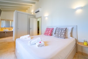 A hotel room with a bed, towels, a bedside table with a glass jar, and a view of the sea. - Ses Rocasses - 8 minutes away from the beach (Santanyi)