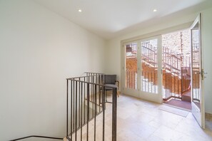 A staircase with a metal railing leading to a door with glass panels. - Ses Rocasses - 8 minutes away from the beach (Santanyi)