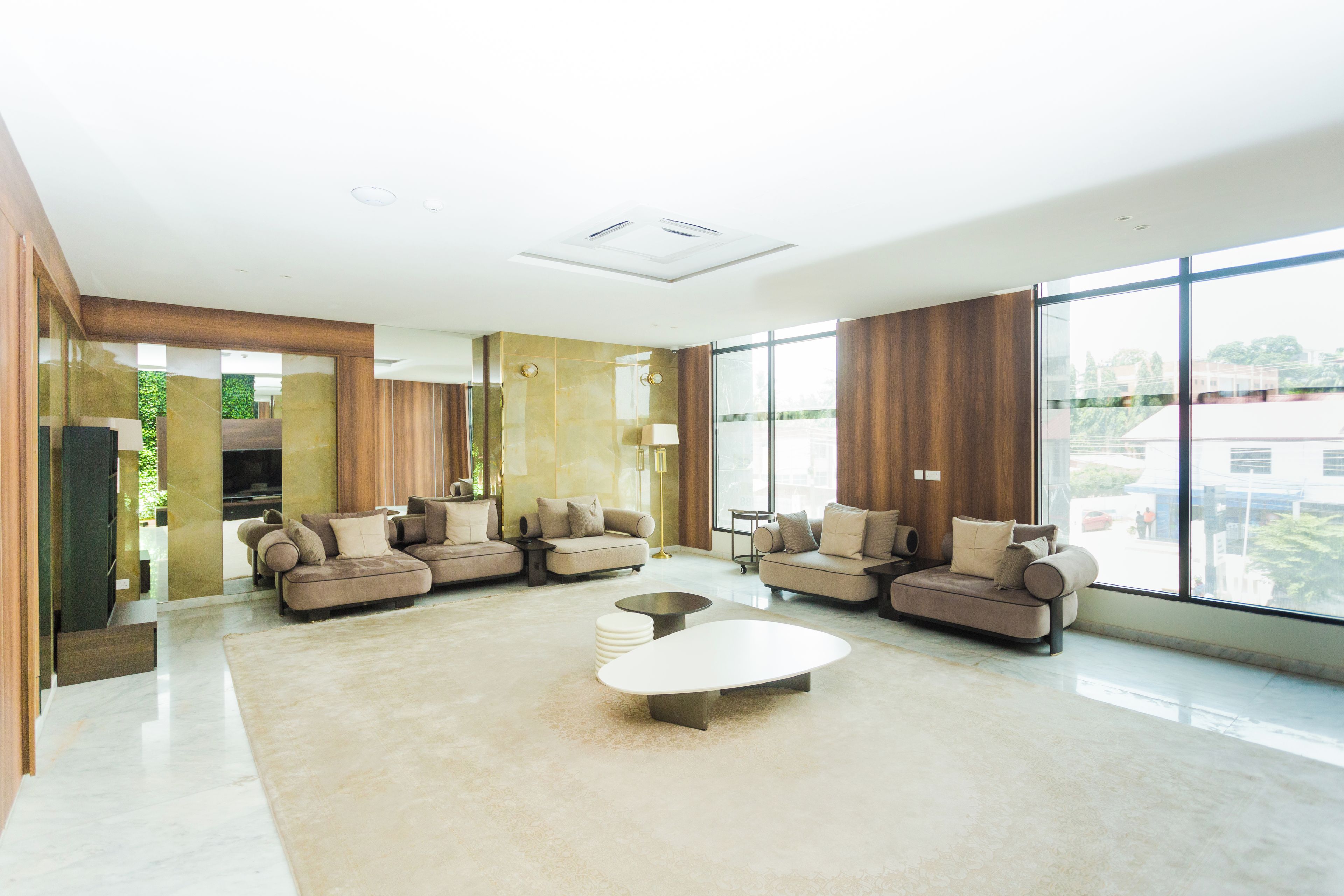 A modern living room with a sectional sofa, a coffee table, and large windows.