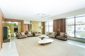 Uma sala de estar moderna com sofá seccional, mesa de centro e grandes janelas.