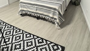 A bedroom with a bed, a window, a wardrobe, and a bedside lamp. - APARTAMENTOS MELISA 12 (Madrid)