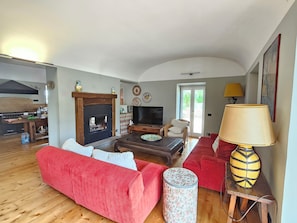A living room with a fireplace, a television, a sofa, a coffee table, and a lamp. - Villa Paradiso in Sabina: Relaxation, Views, and Nature (Montopoli di Sabina)