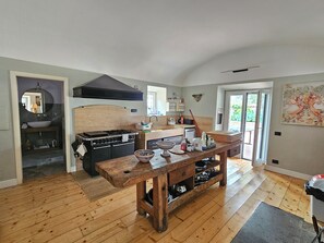 Une cuisine avec une table en bois, une cuisinière et un évier.