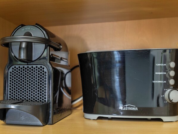 Eine Nespresso-Kaffeemaschine und ein Nespresso-Kaffeierzeuger auf einer Holztischplatte.