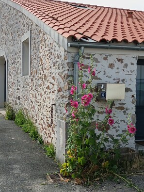A building with a stone facade, a red-tiled roof, and a mailbox marked with the number 6. - La Maison de Jeanne - Maison familiale atypique à Brem sur mer (Brem-sur-Mer)