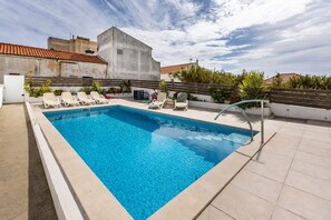 A rectangular swimming pool with a clear blue water surface, surrounded by a tiled deck. - The Sagres House - Village Pool Retreat (Sagres)