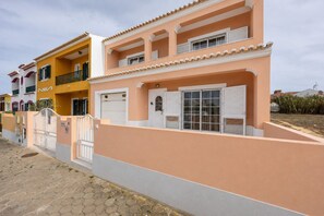 A multi-story residential building with a gated entrance, a garage, and a balcony. - The Sagres House - Village Pool Retreat (Sagres)