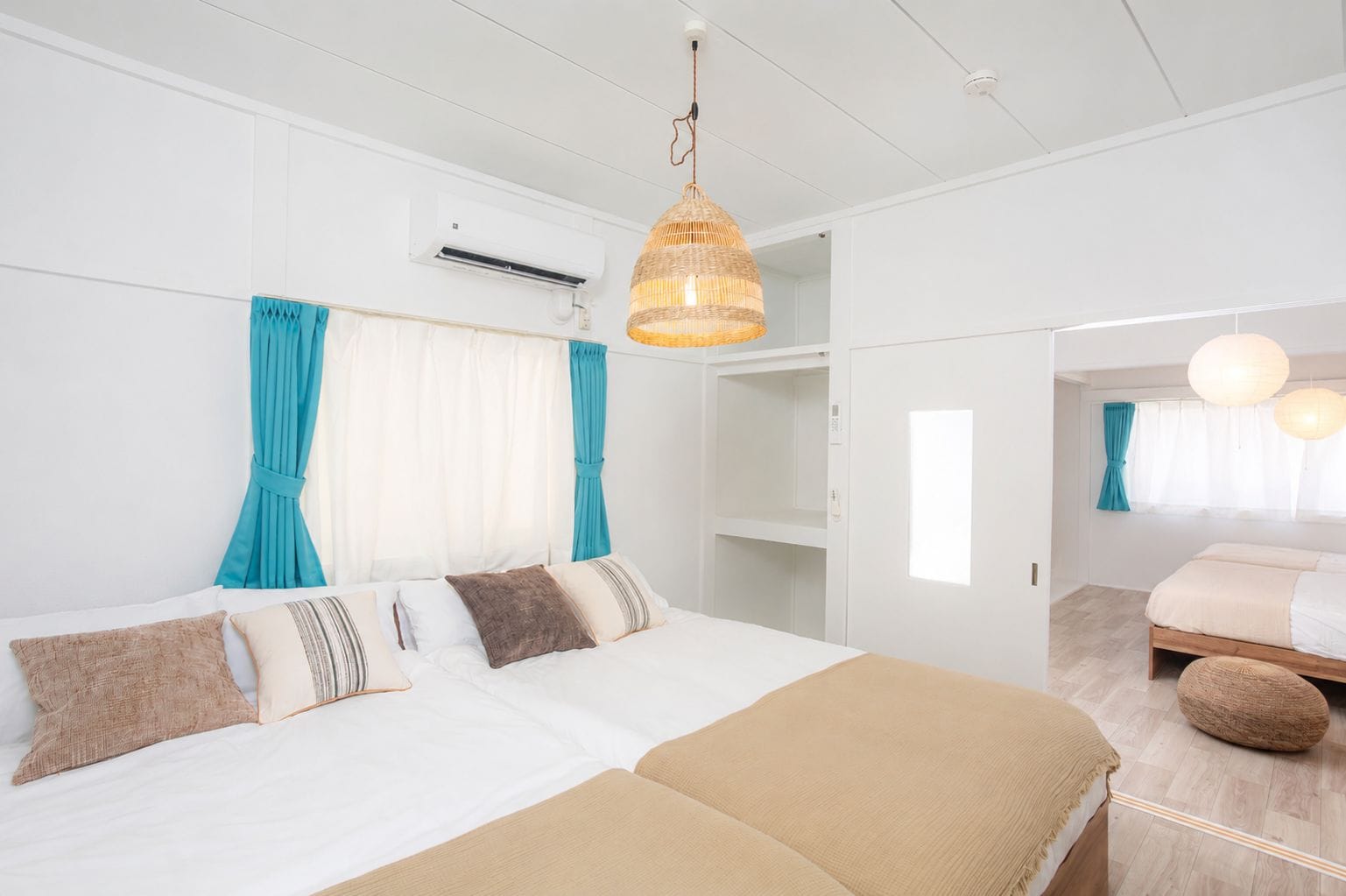 A modern bedroom with a large bed, a wardrobe, and a bathroom visible through an open door.