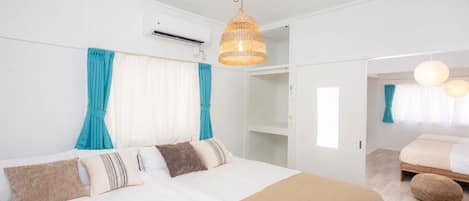 A modern bedroom with a large bed, a wardrobe, and a bathroom visible through an open door.