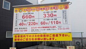 A large sign with pricing information for a parking service, including rates for 24-hour and 8:00-19:00 periods, and a contact number. - Villa CANGGU Osaka/Baika Modern Bali (Konohana-ku, Osaka)