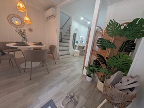 A modern interior with a dining area, staircase, and a shoe rack with plants. - Villa CANGGU Osaka/Baika Modern Bali (Konohana-ku, Osaka)