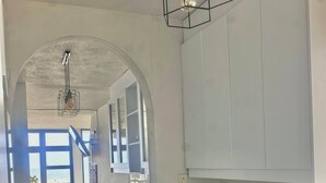 Et vaskerum med vaskemaskine, bordplade og en hængende lampe.