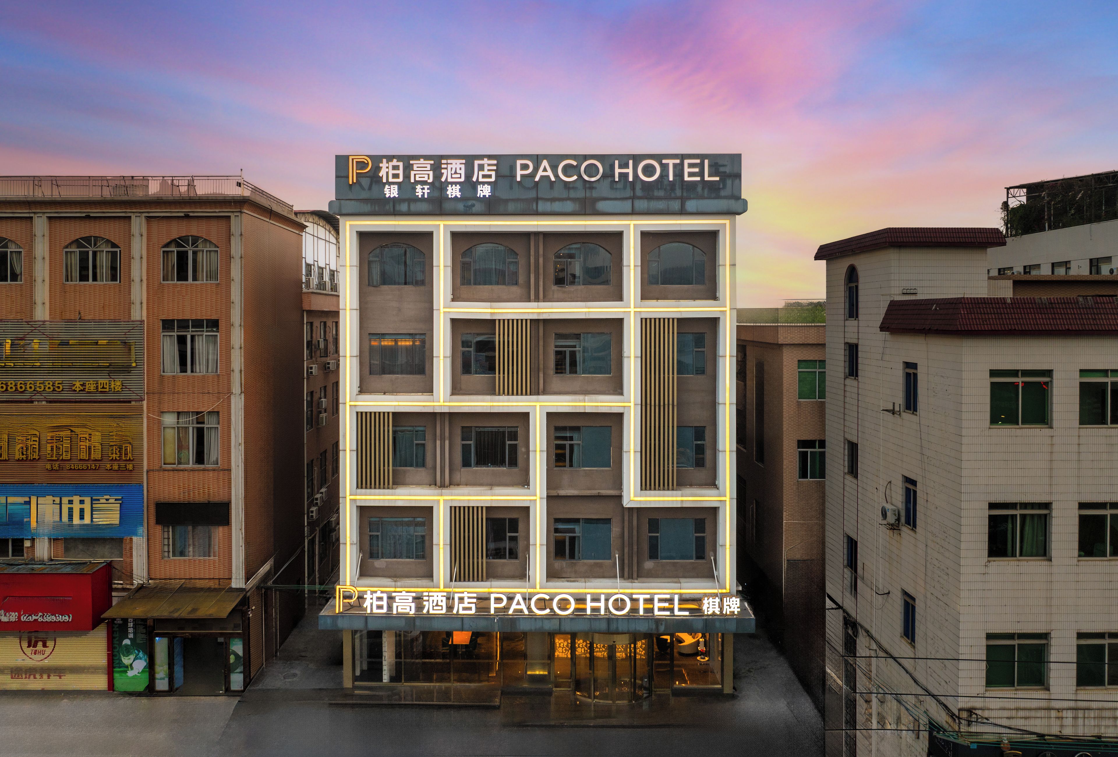 Un edificio de varios pisos con un letrero que dice 'Paco Hotel', indicando que es un hotel.