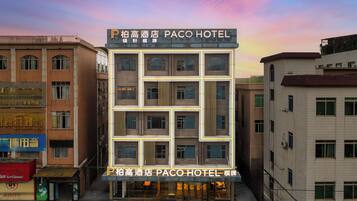 Un edificio de varios pisos con un letrero que dice 'Paco Hotel', indicando que es un hotel.