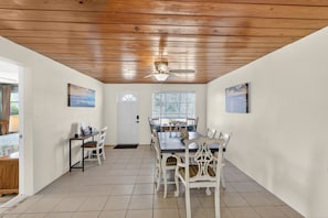 A dining area with a wooden ceiling, white walls, and a large window with blinds. - Lemon Bay Escape - Fishing 10 Min to Beach (Englewood)