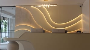 Un mostrador de recepción de diseño moderno, con una parte frontal curva y dos computadoras portátiles encima.