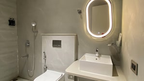 Un baño moderno con inodoro, lavamanos y ducha.