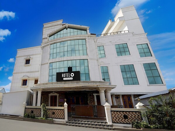 A hotel with a prominent 'HOTEL' sign, a grand entrance with columns, and a large glass facade.