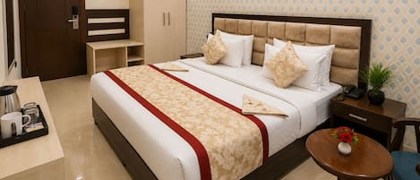 A hotel room with a bed, bedside table, a small round table, a cabinet, and a door.