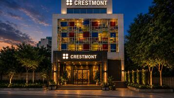 Un hotel Crestmont con fachada de vidrio moderno, una entrada destacada y jardines.