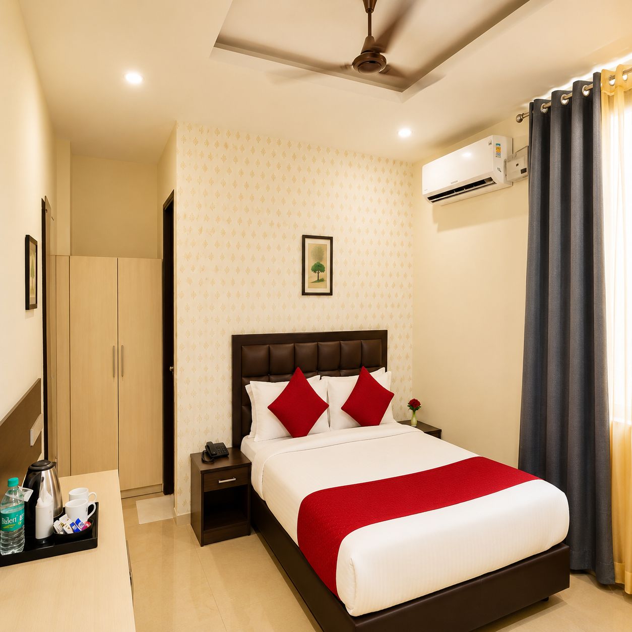 Una habitación de hotel con cama, mesita de noche y aire acondicionado.
