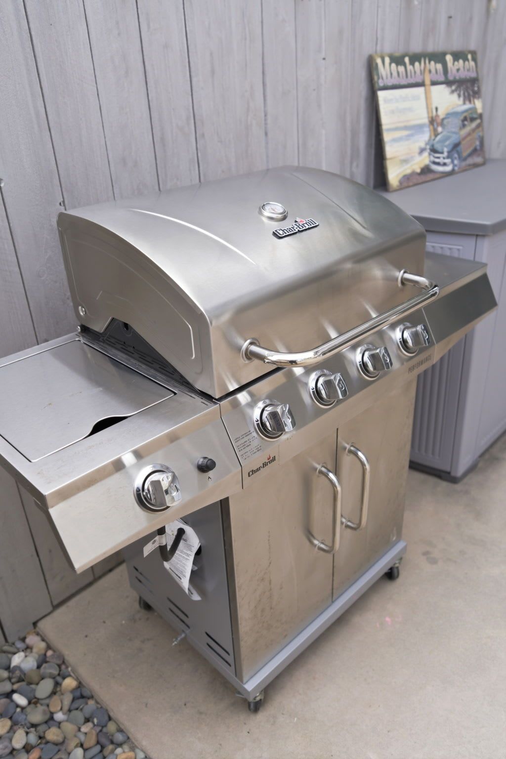A Char-Broil gas grill with a side burner, a control panel, and a storage cabinet.