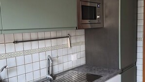 A kitchen with a stainless steel sink, a microwave, and a refrigerator. - Due Passi di Blu: Your own little oasis of relaxation just a few steps from the sea in Anzio (Anzio)