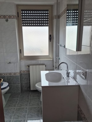 A bathroom with a window, a sink, a toilet, and a radiator. - Due Passi di Blu: Your own little oasis of relaxation just a few steps from the sea in Anzio (Anzio)