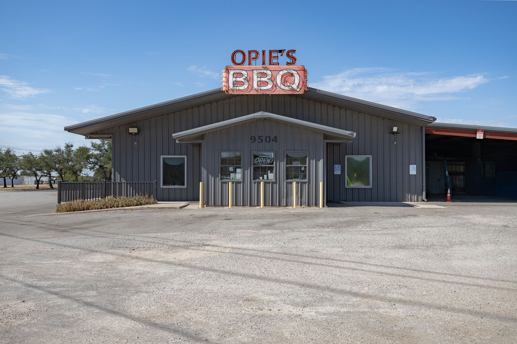 Een gebouw met een bord waarop 'OPIE'S BBQ' staat en het nummer '9504' op de gevel.