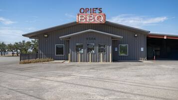 Een gebouw met een bord waarop 'OPIE'S BBQ' staat en het nummer '9504' op de gevel.