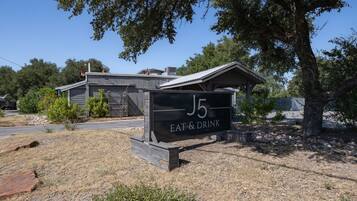 A sign for 'J5 Eat & Drink' with a building in the background.