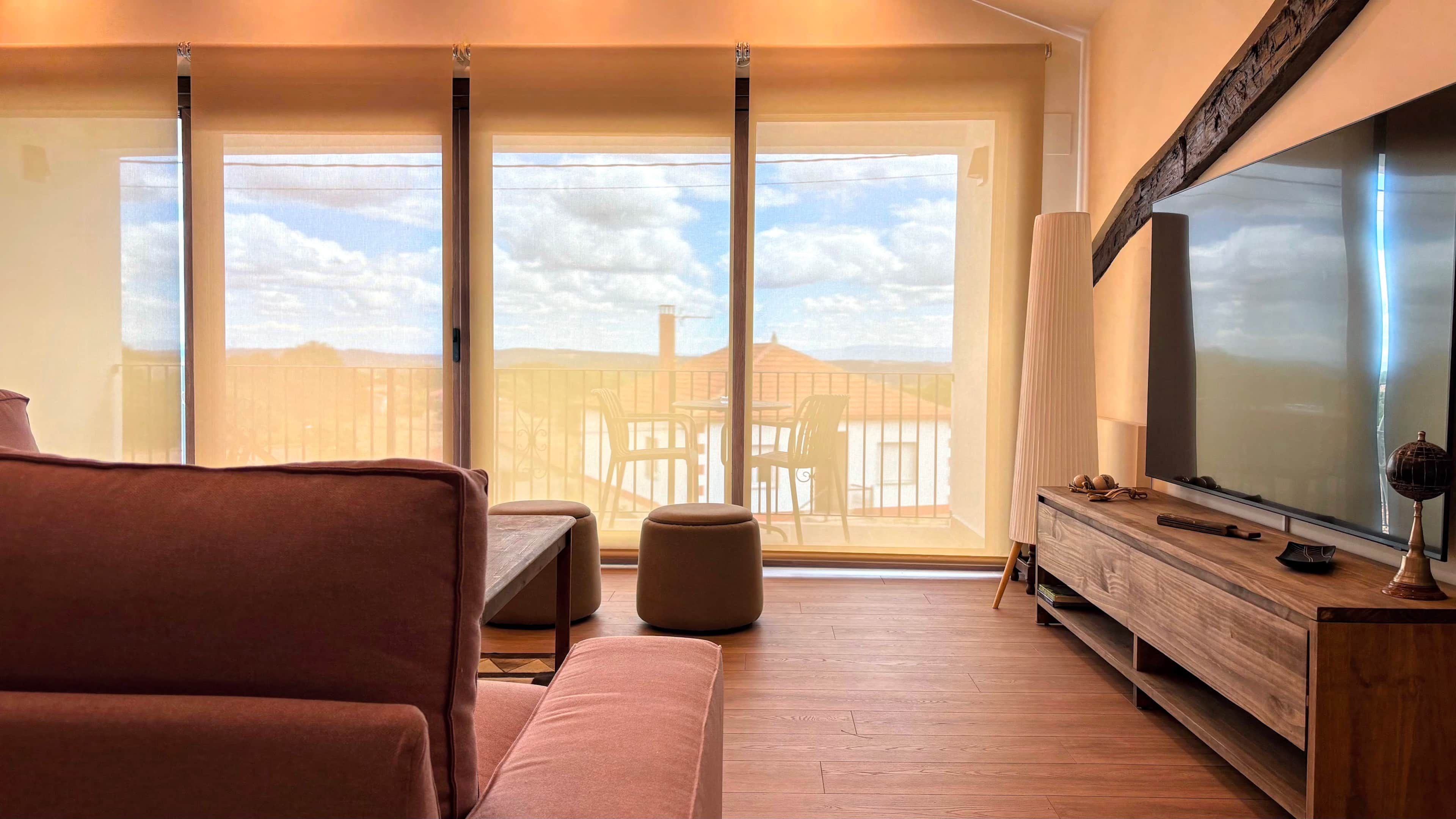 A living room with a sofa, a coffee table, and a TV on a wooden stand.