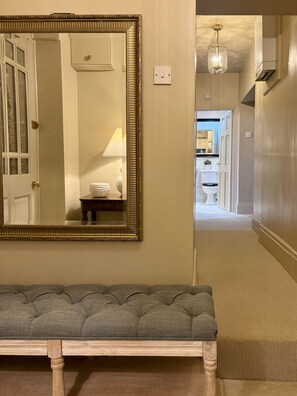 A hallway with a bench, a large mirror, and a light fixture. - The West Wing Sleeps 5 With Parking (Barnard Castle)
