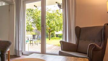 Una habitación con puerta corredera de vidrio que da a un patio exterior.