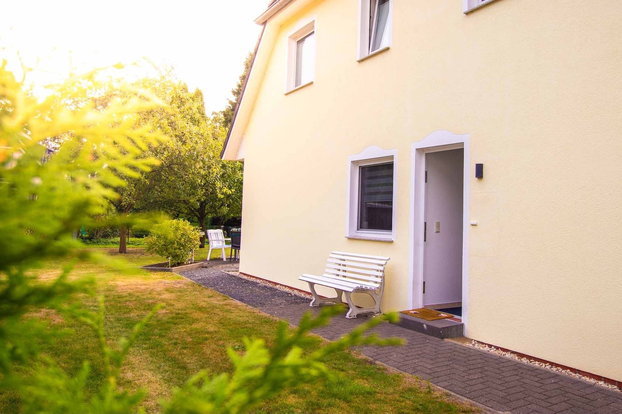 Un bâtiment jaune avec un banc à l’extérieur, une porte et une fenêtre.