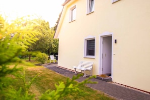 Un bâtiment jaune avec un banc à l’extérieur, une porte et une fenêtre.