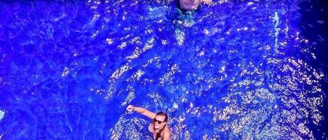 Una piscina con dos personas nadando.