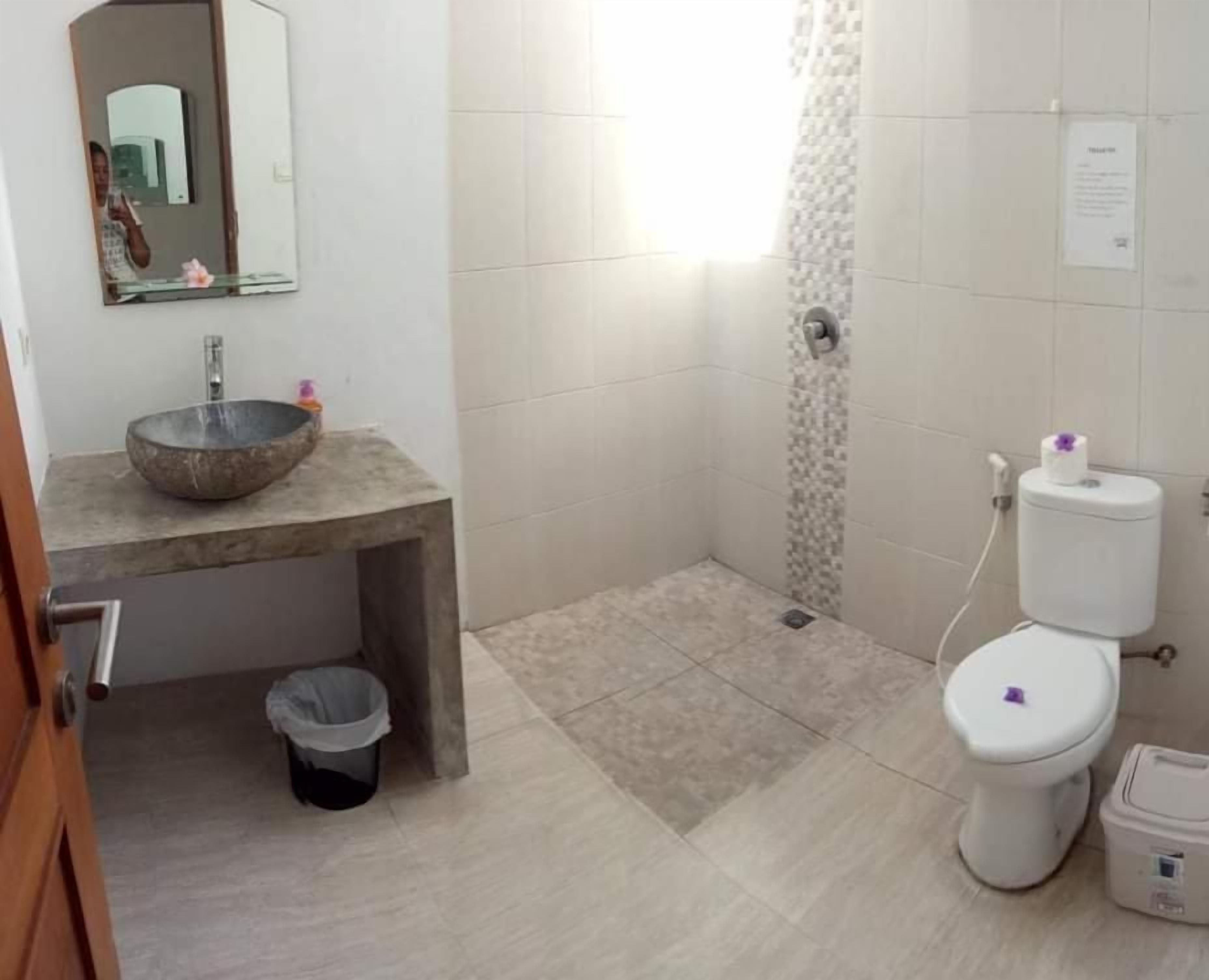 A bathroom with a large sink, toilet, and shower area.